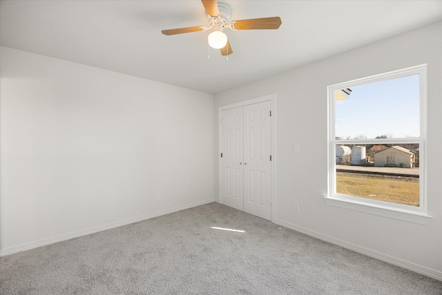 carpeted empty room featuring ceiling fan