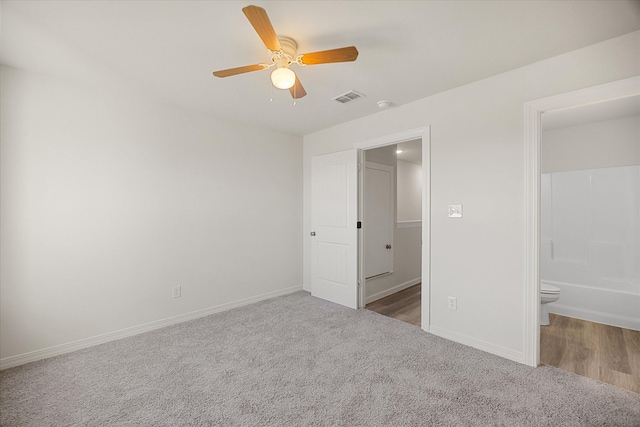 unfurnished bedroom with ensuite bathroom, carpet, and ceiling fan