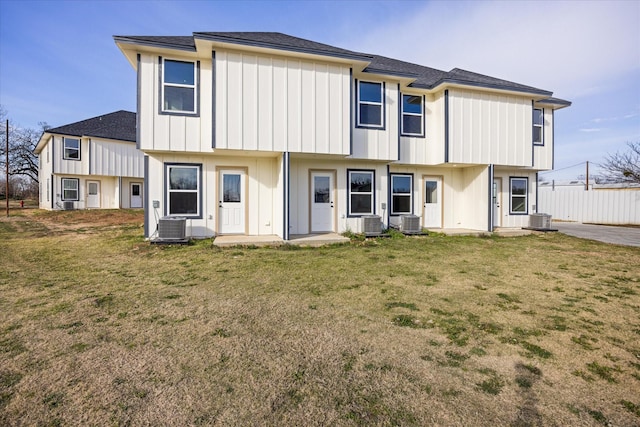 rear view of property featuring a yard and central AC unit