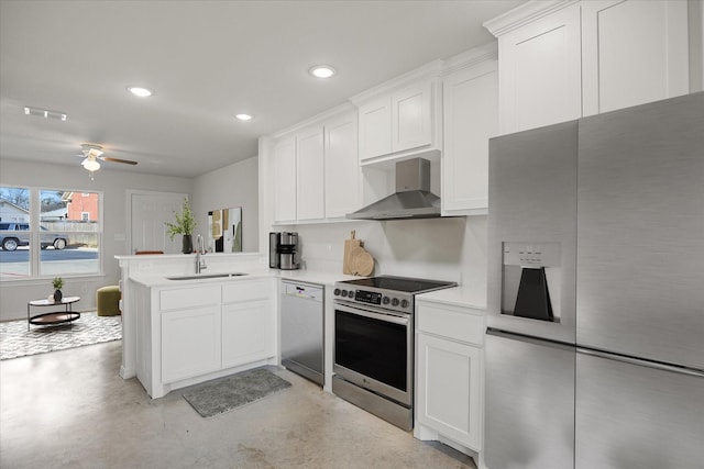 kitchen featuring sink, white cabinets, kitchen peninsula, stainless steel appliances, and wall chimney exhaust hood