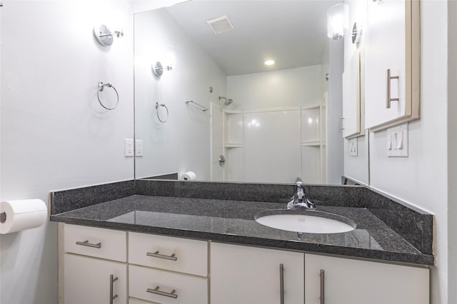 bathroom featuring a shower and vanity