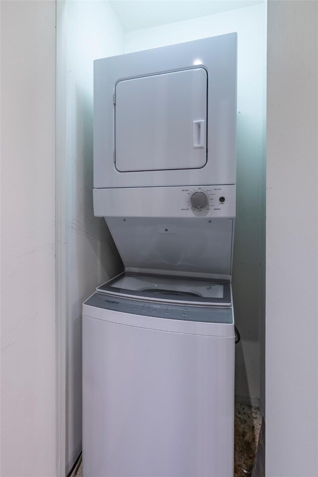 clothes washing area with stacked washer / dryer