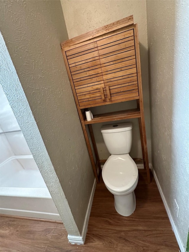 bathroom with hardwood / wood-style flooring and toilet