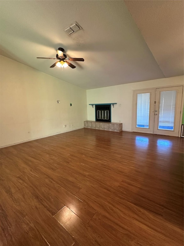 unfurnished living room featuring dark hardwood / wood-style flooring, a fireplace, ceiling fan, and vaulted ceiling