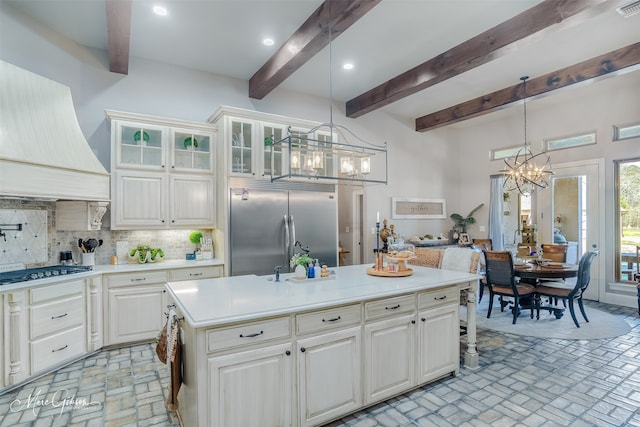 kitchen featuring hanging light fixtures, premium range hood, a chandelier, and appliances with stainless steel finishes