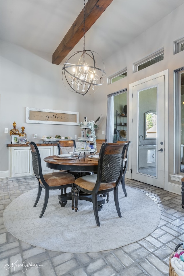 dining room featuring beam ceiling and a chandelier