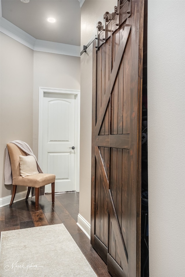 living area featuring ornamental molding, a barn door, and dark wood-type flooring