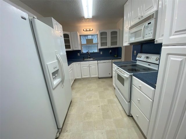 kitchen featuring a textured ceiling, white appliances, white cabinetry, and sink