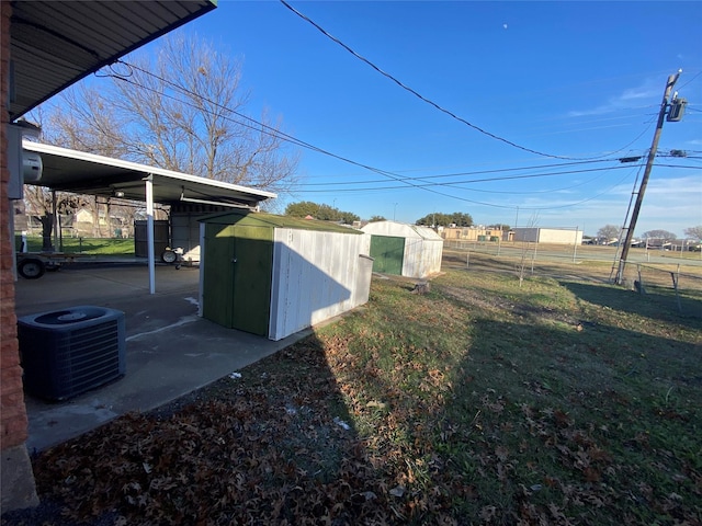 view of yard with central AC and a shed