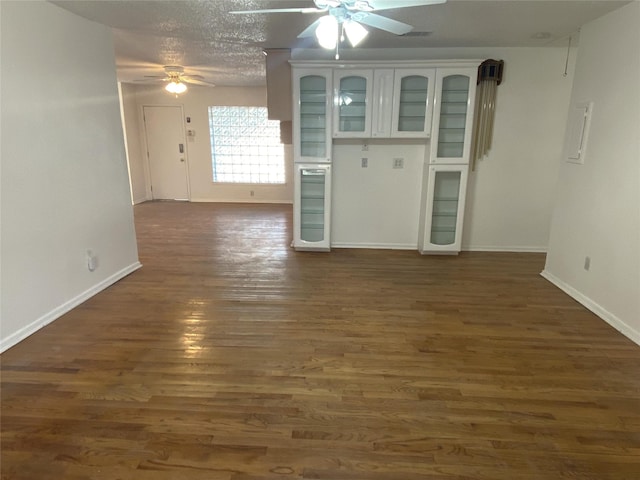 unfurnished living room featuring a textured ceiling and dark wood-type flooring