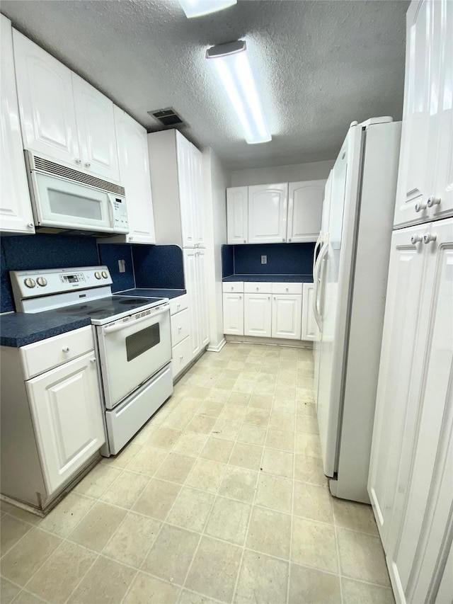 kitchen featuring a textured ceiling, backsplash, white cabinets, and white appliances