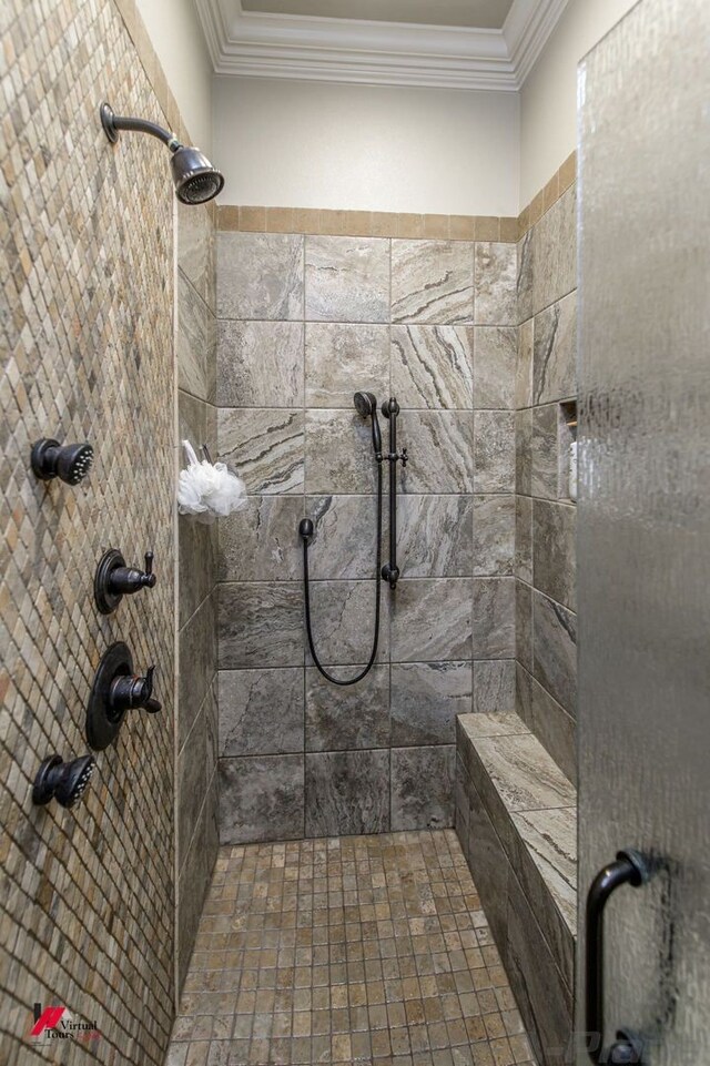 bathroom with a tile shower and ornamental molding