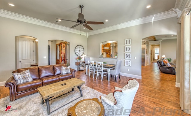 living room with ceiling fan, light wood-type flooring, and ornamental molding