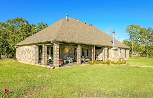 rear view of house featuring a lawn and a patio