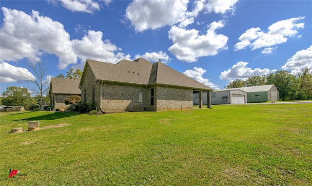 rear view of property featuring a yard, an outbuilding, and a garage