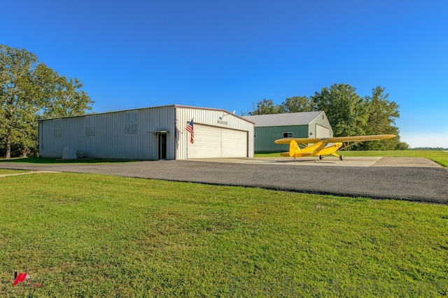 view of outdoor structure with a garage and a lawn