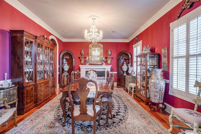 dining room featuring hardwood / wood-style floors, crown molding, and a chandelier