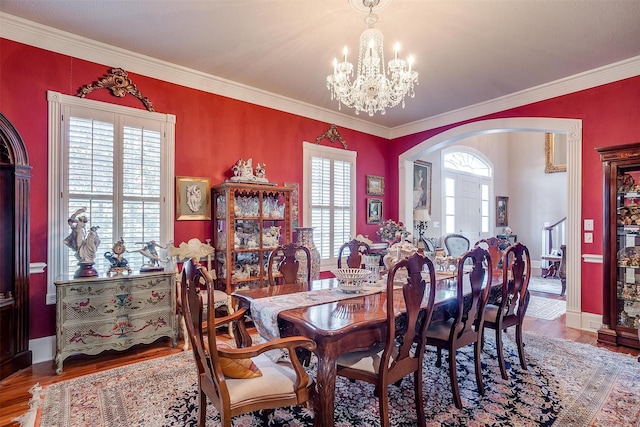 dining area featuring hardwood / wood-style floors, ornamental molding, and a chandelier