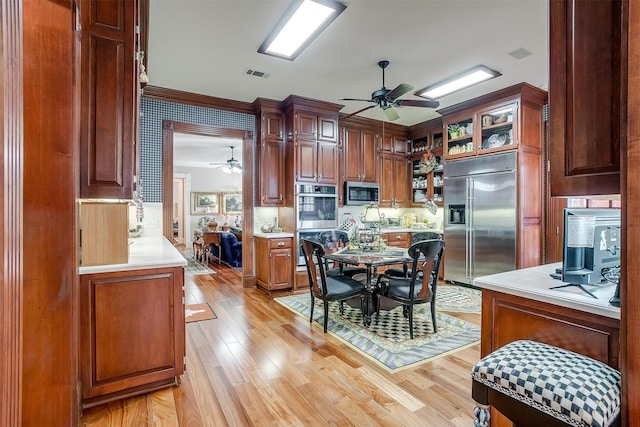 kitchen with stainless steel appliances, light hardwood / wood-style flooring, and ceiling fan