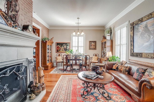 living room with hardwood / wood-style flooring, a healthy amount of sunlight, brick wall, and an inviting chandelier