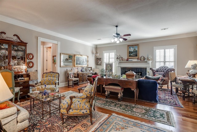 living room featuring a textured ceiling, hardwood / wood-style flooring, ceiling fan, and crown molding