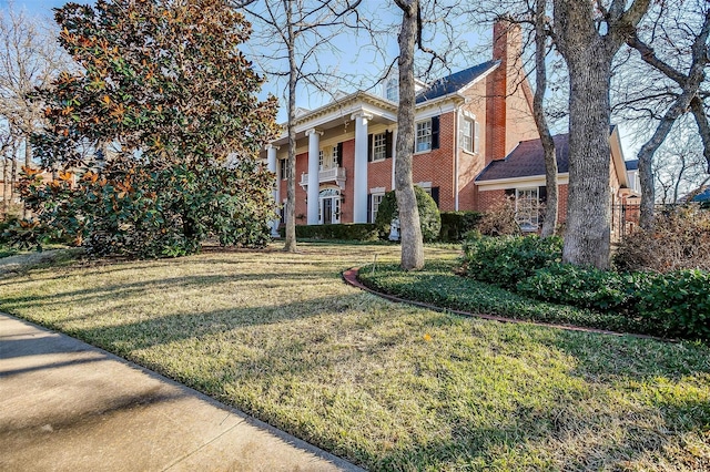 view of front facade with a balcony and a front yard