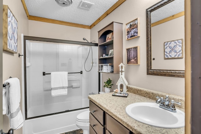 full bathroom featuring shower / bath combination with glass door, ornamental molding, vanity, toilet, and a textured ceiling