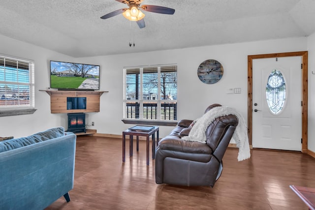 living room with ceiling fan, dark wood-type flooring, a fireplace, and a textured ceiling