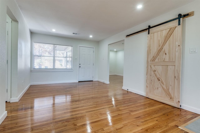 interior space with a barn door and light hardwood / wood-style floors