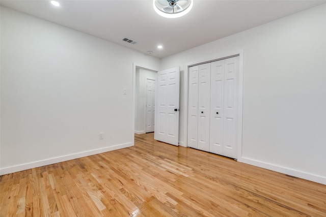 unfurnished bedroom with a closet and light hardwood / wood-style floors