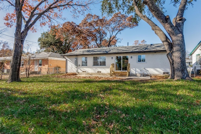 rear view of property featuring a lawn