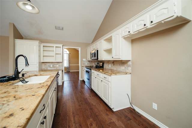 kitchen featuring stainless steel appliances, white cabinets, light stone counters, and sink