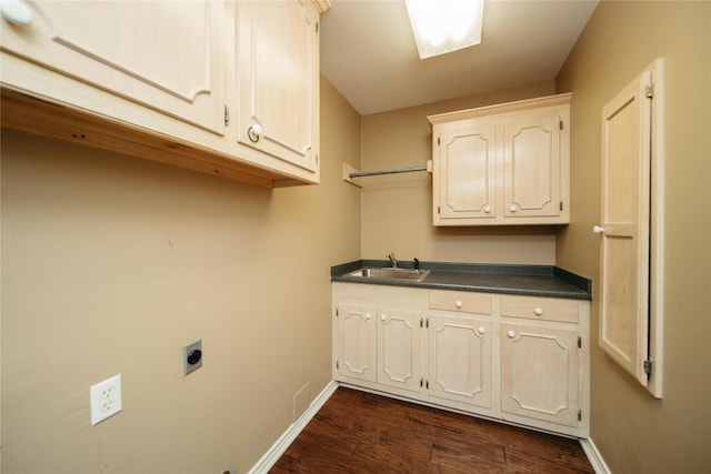 clothes washing area with cabinets, electric dryer hookup, sink, and dark hardwood / wood-style floors