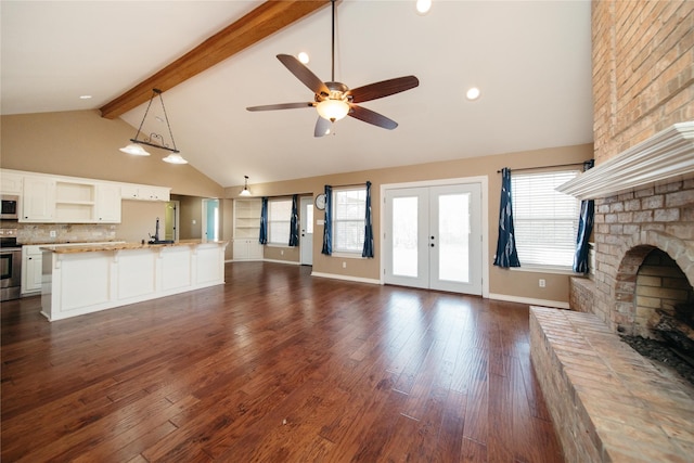 unfurnished living room with ceiling fan, dark hardwood / wood-style flooring, a brick fireplace, and beamed ceiling