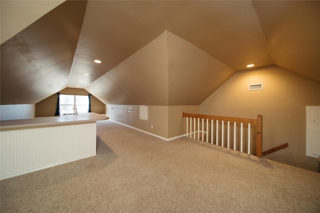 bonus room with lofted ceiling, sink, and carpet