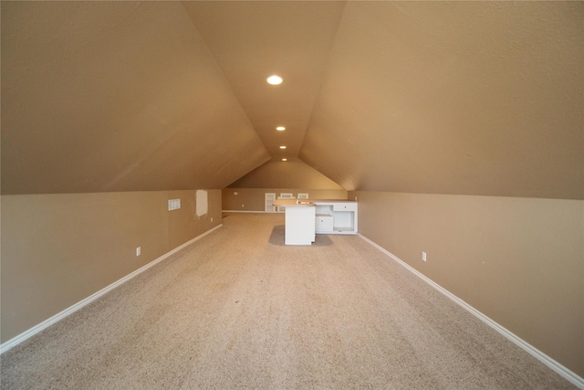 additional living space with carpet flooring and vaulted ceiling