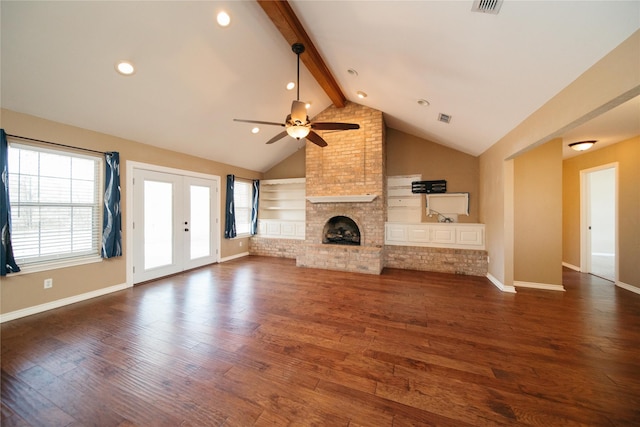 unfurnished living room with dark hardwood / wood-style floors, vaulted ceiling with beams, ceiling fan, a brick fireplace, and french doors