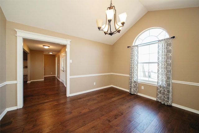 spare room with lofted ceiling, dark wood-type flooring, and a chandelier