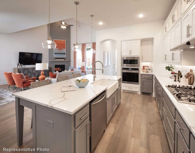 kitchen featuring stainless steel appliances, white cabinetry, a kitchen island with sink, and gray cabinetry