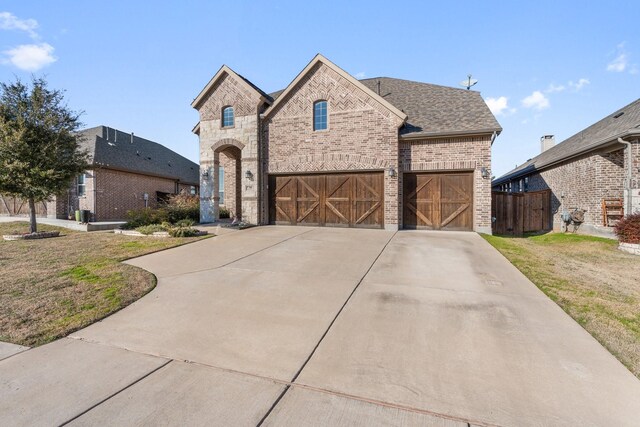 view of front of home with a garage and a front lawn