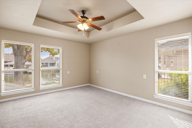 unfurnished room featuring carpet, ceiling fan, and a tray ceiling