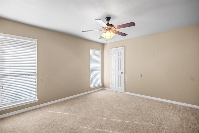 carpeted spare room with ceiling fan