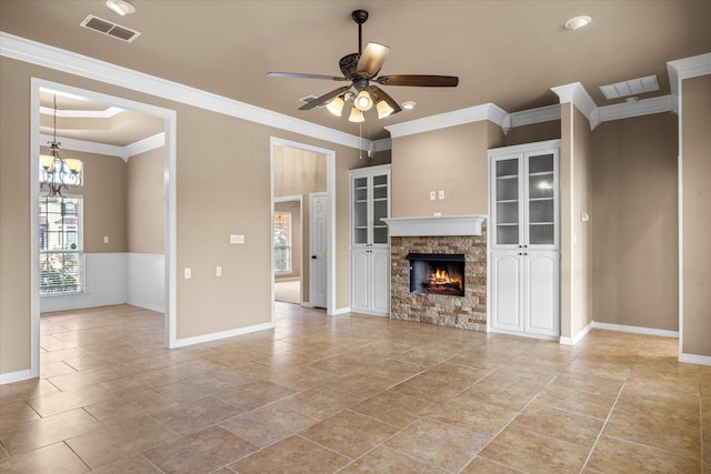 unfurnished living room with ceiling fan with notable chandelier, a stone fireplace, and ornamental molding