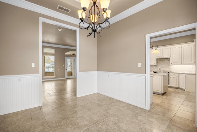 tiled spare room featuring a chandelier and ornamental molding