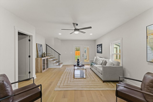 living room with french doors, light wood-type flooring, and ceiling fan