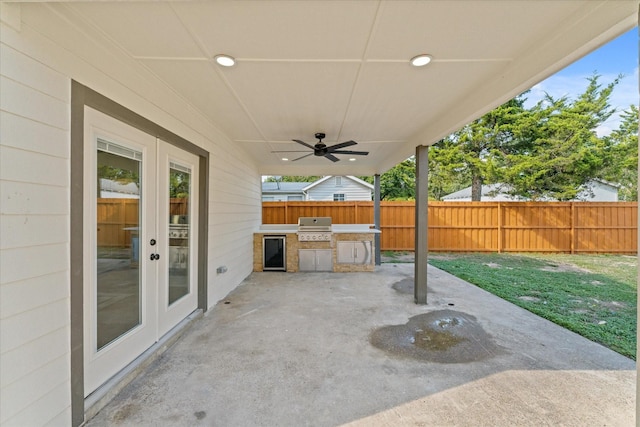 view of patio / terrace with french doors, area for grilling, ceiling fan, and exterior kitchen