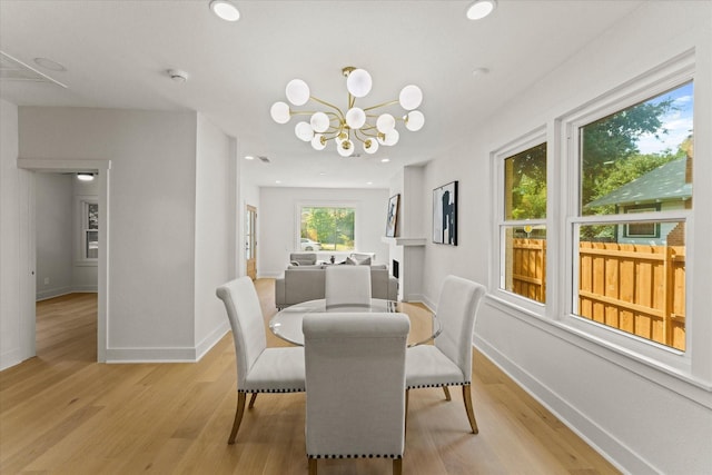 dining space with an inviting chandelier and light hardwood / wood-style flooring