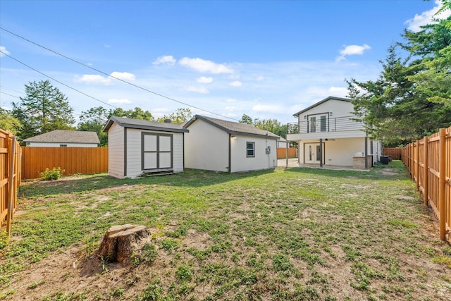 view of yard with a balcony and a storage shed