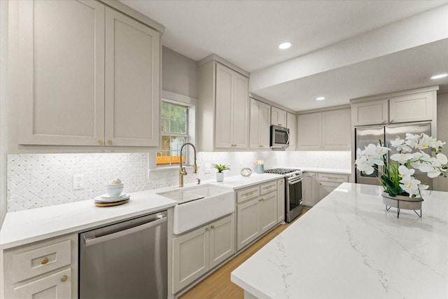 kitchen with decorative backsplash, gray cabinets, sink, and appliances with stainless steel finishes