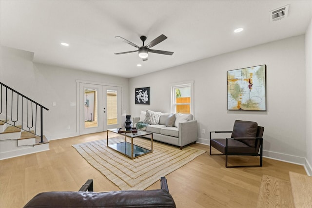 living room with french doors, ceiling fan, and light hardwood / wood-style floors